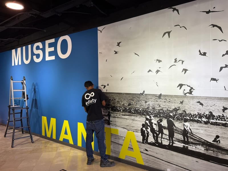 Técnico de Infinity instalando el mural fotográfico y las letras corpóreas de un museo
